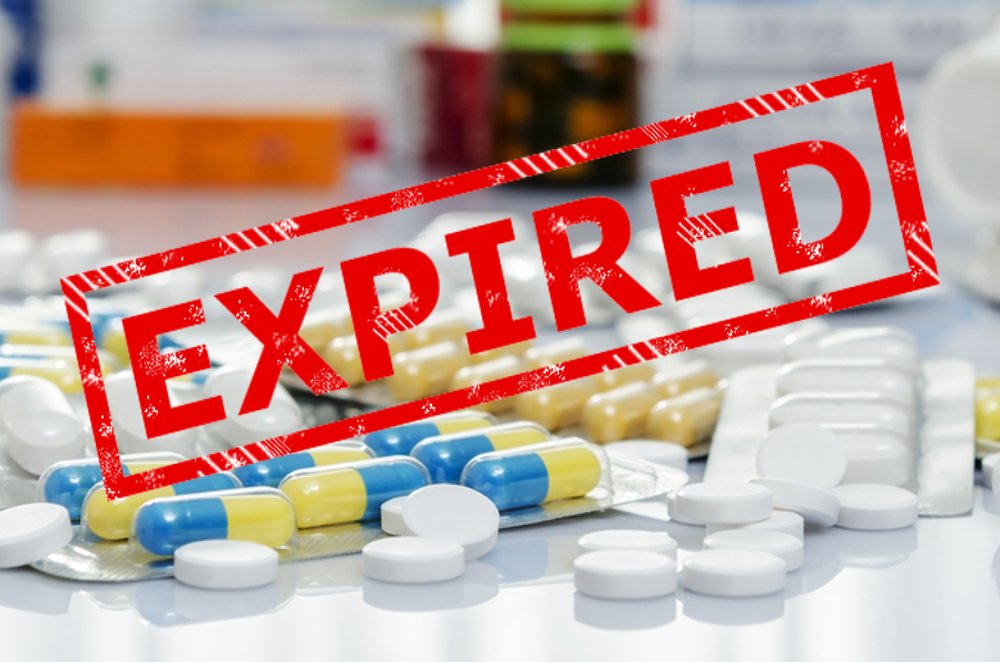 pills scattered on table with "Expired" stamp text